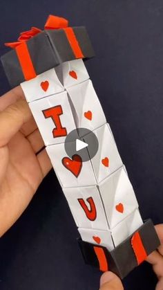 someone is holding an origami piece with the word i love you on it