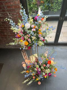 a tall vase filled with lots of different colored flowers next to a window sill