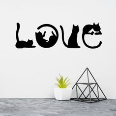 a wall decal with the word love and two cats sitting on top of it