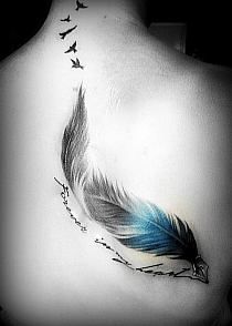 a woman's back with a blue and black feather tattoo on it