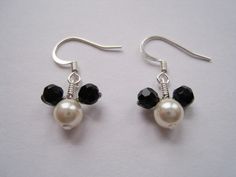 two black and white beads are attached to silver earwires with swaroons