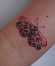 a small butterfly tattoo on the arm