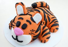 a cake shaped like a tiger laying on top of a white plate