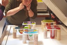 a woman is looking at her cell phone while standing in front of an assortment of toys