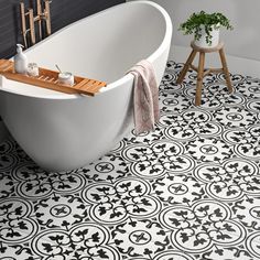 a bath tub sitting next to a wooden stool in a blue and white tiled bathroom