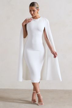 Cut to a demure midi length, Rafaela is the perfect pick for any upcoming formal event. Crafted in a crisp white shade of our signature stretch crepe, this bodycon is defined by a captivating cape feature that flows artfully behind you. For an elegant bachelorette attire, try styling yours with some statement stilettos like Just A Fling.   Features  - Premium stretch crepe - Bodycon fit  - Crew neckline  - Cape detail - Invisible zip closure - Midi length    Sizing & Fit  Model is 5'8 and wears UK size 8 / US size 4   Product Information     Double layered with good stretch  Premium crepe in White (95% Polyester, 5% Elastane)  120cm total length  SKU:CL131034005 Bachelorette Attire, Dress With Cape Sleeves, White Midi Dress Bodycon, Dramatic Dresses, Dress With Cape, Black Dress Prom, White Bodycon, Black Tie Gala, Cape Sleeves