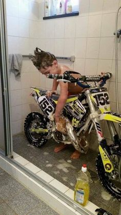 a young person on a dirt bike in a shower stall with water and other items