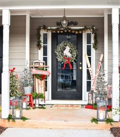 a front porch decorated for christmas with wreaths and baseball bats on the door sill