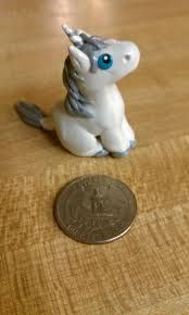 a small toy horse sitting next to a penny on a table with a wooden surface