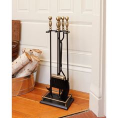 a black and gold candle holder sitting on top of a wooden floor next to a door