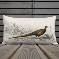 a pillow with a pheasant on it sitting on top of a wooden table