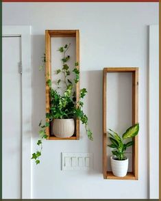 two wooden boxes with plants in them on the wall