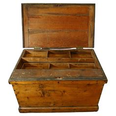 an old wooden box with compartments on the top and bottom is open to show what's inside