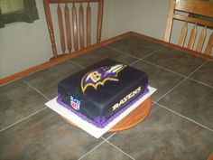 a cake that is sitting on top of a tile floor in front of a table