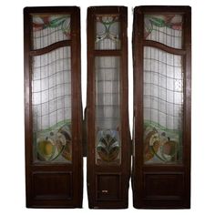 two wooden doors with stained glass panels on the top and bottom, side by side