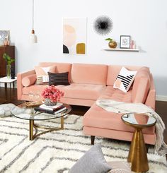 a living room with pink couches and white rugs on the hardwood flooring