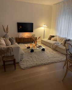 a living room filled with furniture and a flat screen tv mounted to the side of a wall