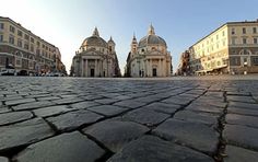 the sun shines brightly on an old cobblestone street in front of buildings