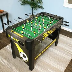 a foosball table with soccer balls and sticks on it in a living room