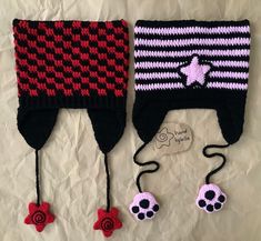 two crocheted hats with red, black and white designs on the top one has a skull in the middle