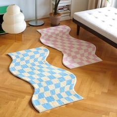 three rugs on the floor in a living room with a couch and table behind them