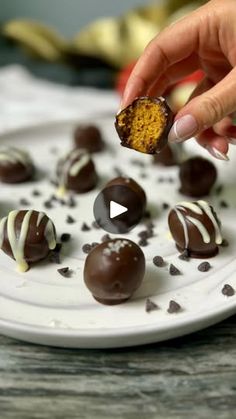 a person is picking up some chocolates on a plate