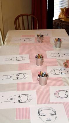 a child sitting at a table with some drawings on it