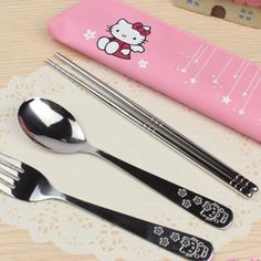 hello kitty utensils and spoons on a doily next to a pink case