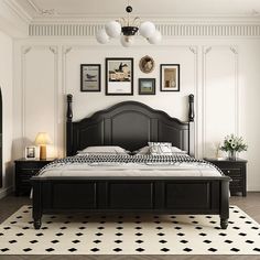 a black and white bedroom with pictures on the wall above the bed, along with an area rug