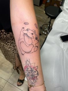 a woman's arm with a tattoo on it that has an image of a bear