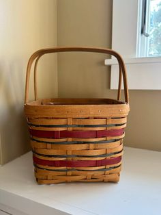 a woven basket sitting on top of a white counter next to a window in a room