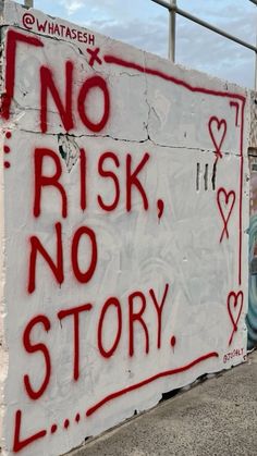 a sign that has been vandalized on the side of a building says no risk, no story