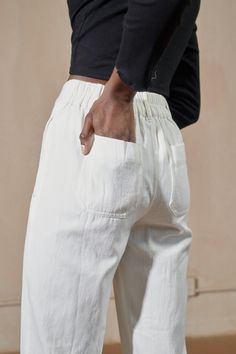 A menswear inspired straight leg trouser with front pleats. Now featured in silk-like cupro for an elevated look. Curved side pockets finish with self piping and back patch pockets. Single seashell button with zip fly closure. Belt loops. Elastic back waistline for an easy fit. A 30” inseam with a 2” cuff for longer inseams. Cream Relaxed Fit Pants With Straight Hem, Cream Wide Leg Pants With Patch Pockets, Everyday White Pants With Patch Pockets, Retail Aesthetic, High Iron, Selvedge Denim, Menswear Inspired, Straight Leg Trousers, Delhi India