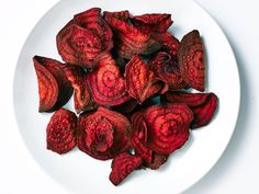 a white plate topped with red flowers on top of a table