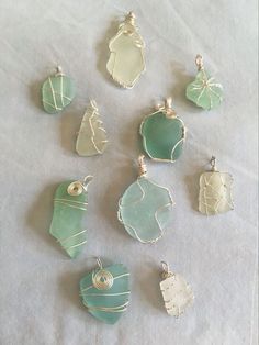 nine sea glass pendants on a white sheet