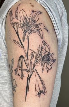 a black and white photo of a flower tattoo on the left upper half of the arm