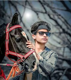 a young man is holding the reins of a horse while wearing sunglasses and a bandana