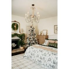 a bedroom with a christmas tree in the corner and a chandelier hanging from the ceiling