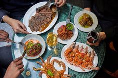 people are sitting at a table with plates of food