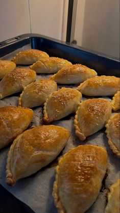 baked pastries are lined up on a baking sheet