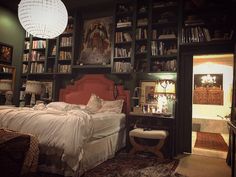 a bed sitting in a bedroom next to a book shelf filled with books