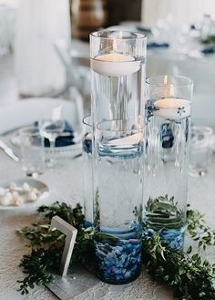 the centerpieces are filled with candles, greenery and other things to decorate