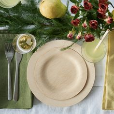 a table set with plates, silverware and flowers