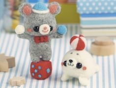 two small stuffed animals sitting next to each other on a table