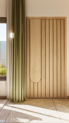 an empty room with a wooden door and green drapes on the window sill