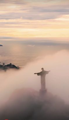 the statue of christ surrounded by fog and low lying clouds in rio francisco, chile