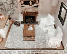 an aerial view of a living room with white furniture and accessories on the floor, including a coffee table