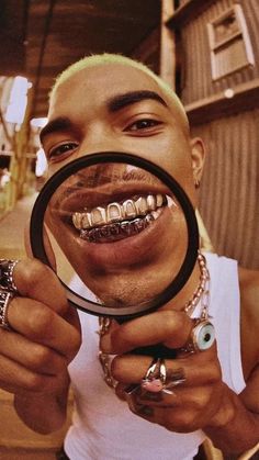 a man holding a magnifying glass with teeth on it