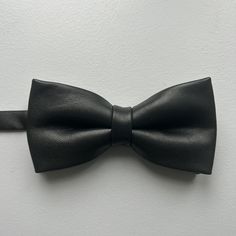 The bow tie, an accessory that has spanned the centuries, providing a unique and authentic look, always contemporary. Thanks to our premium quality leathers, we have created a haute couture accessory that finishes off your outfit. A jewelry trend for women, it goes perfectly with a dressy outfit or simply with a casual shirt. For men, it adds style to your suit or brings a dressy touch to your casual outfit. Symbol of dandy style, we loved making this ideal accessory for all your events. 100% le Elegant Fitted Bow For Gift, Elegant Fitted Bow As Gift, Black Bow Tie With Butterfly Knot For Business, Classic Adjustable Bow For Business, Black Butterfly Knot Bow Tie For Business, Adjustable Classic Bow For Business, Classic Bow With Butterfly Knot For Party, Dapper Butterfly Knot Bow For Party, Elegant Adjustable Bow With Decorative Design