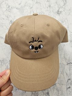 a person holding up a brown hat with a face drawn on the front and side